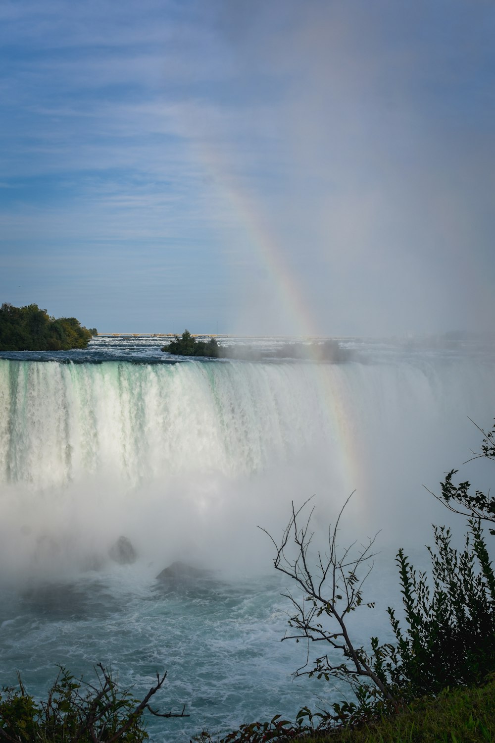 water falls under blue sky during daytime