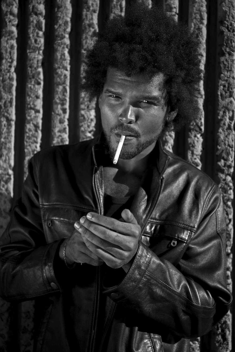 man in black leather jacket smoking