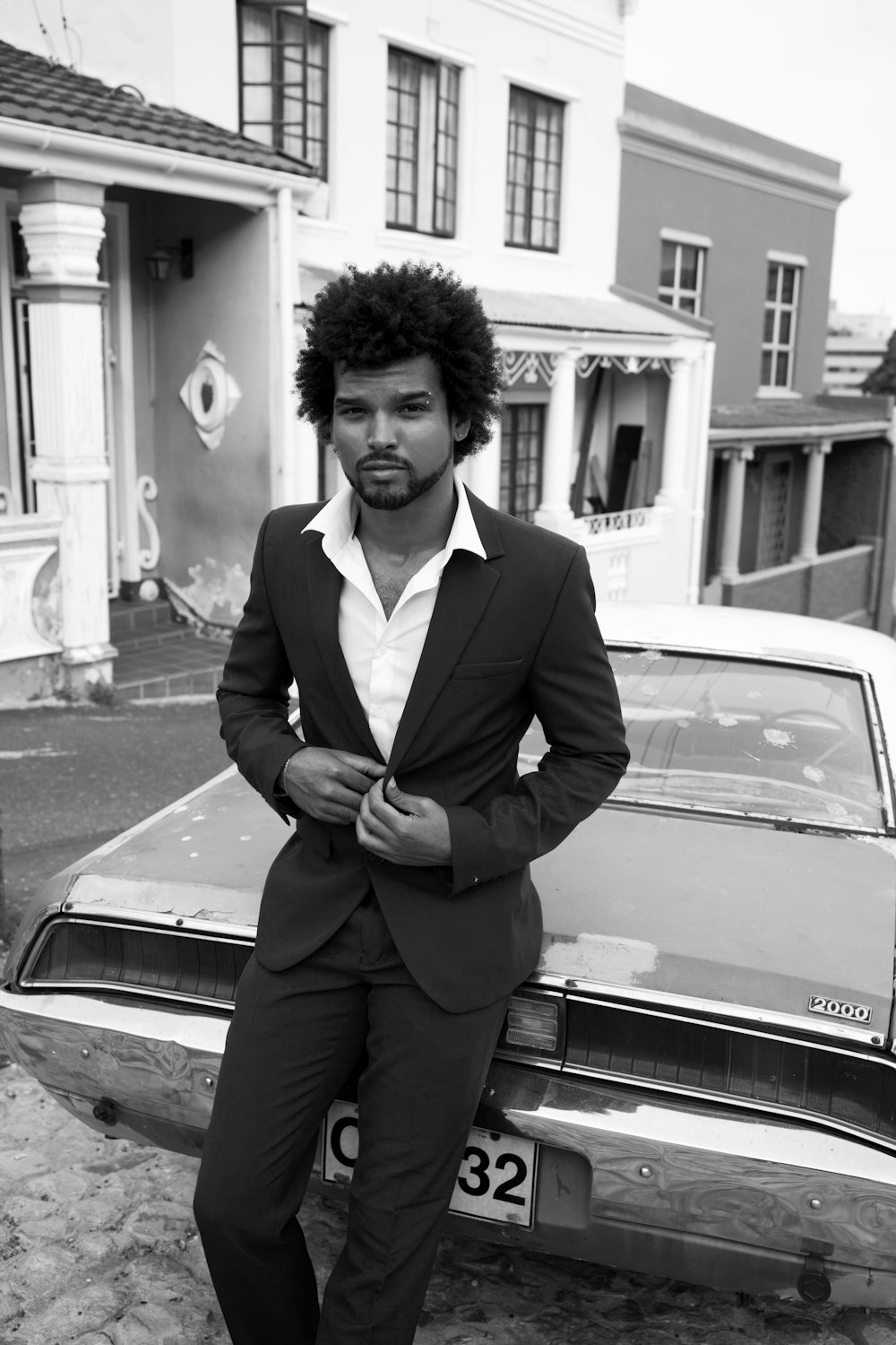 man in black suit standing beside car