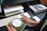 Smiling young professional woman working at her desk with a healthy lunch beside her.