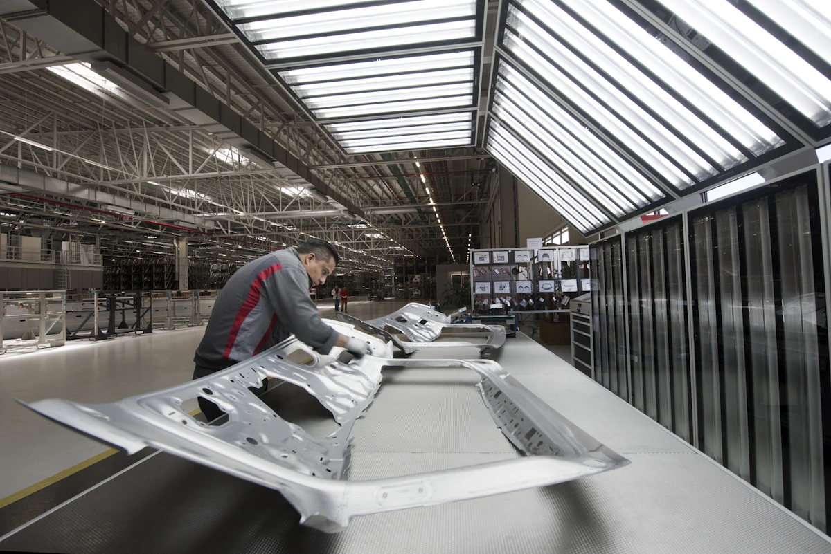 Quality control inspector examining a vehicle body panel on a modern automotive production line