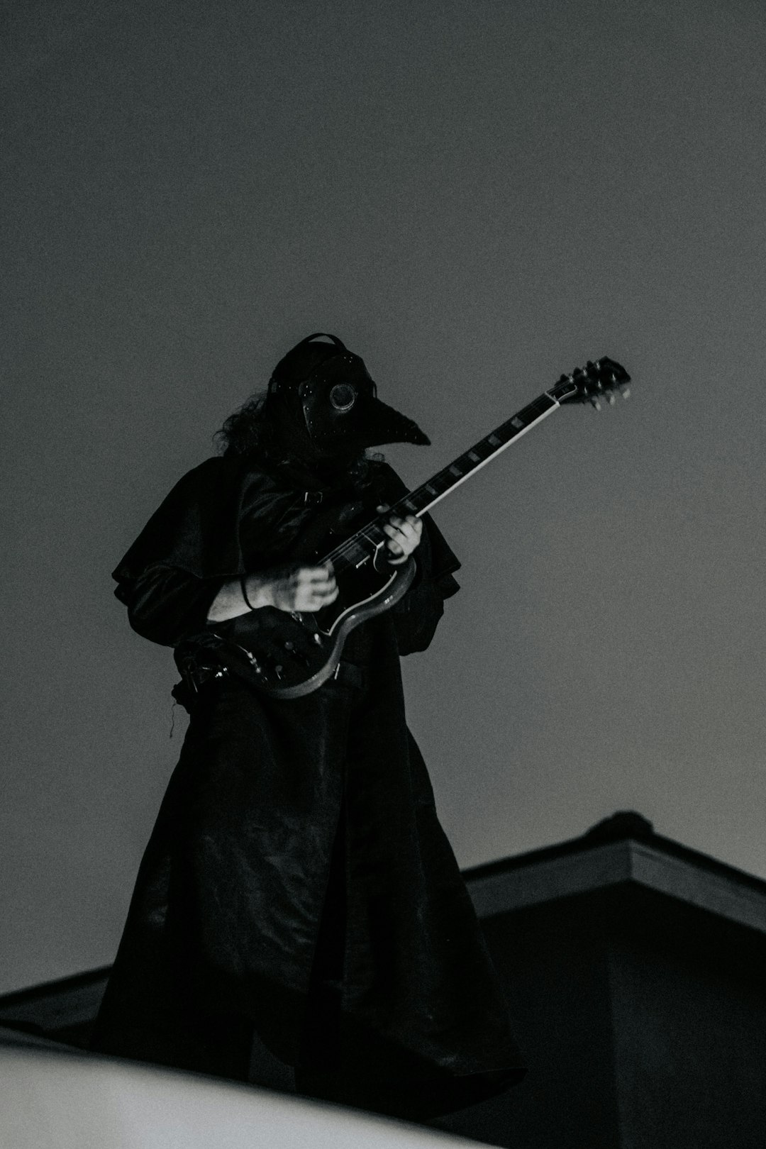 person in black coat playing guitar