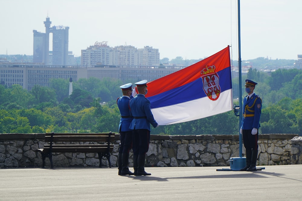 man in black jacket standing near flag of us a during daytime