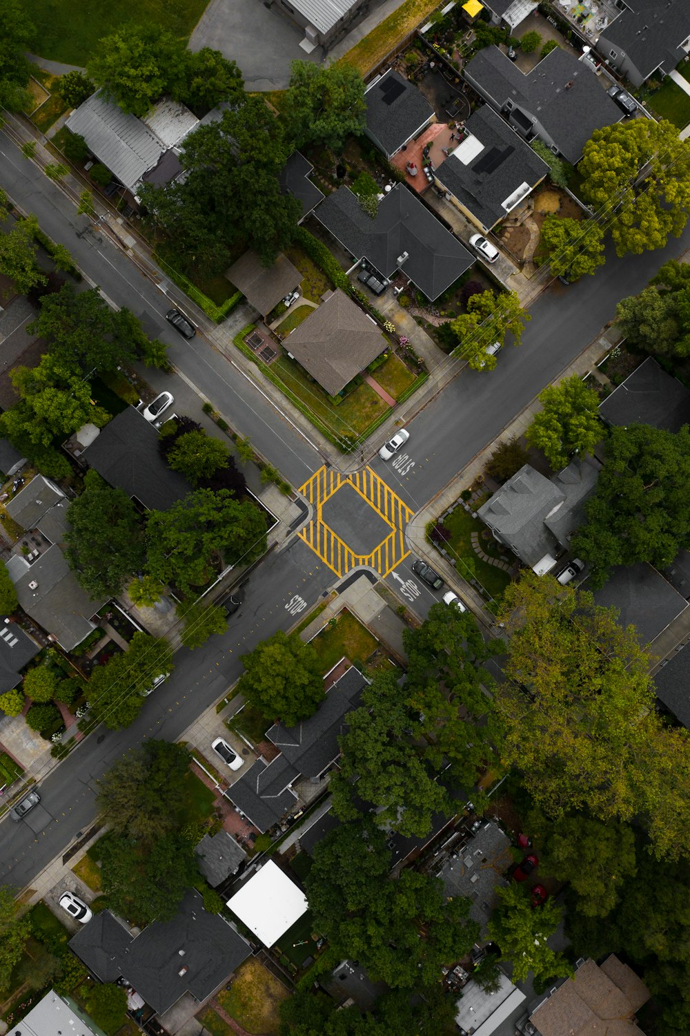 an aerial view of a street intersection with a yellow triangle