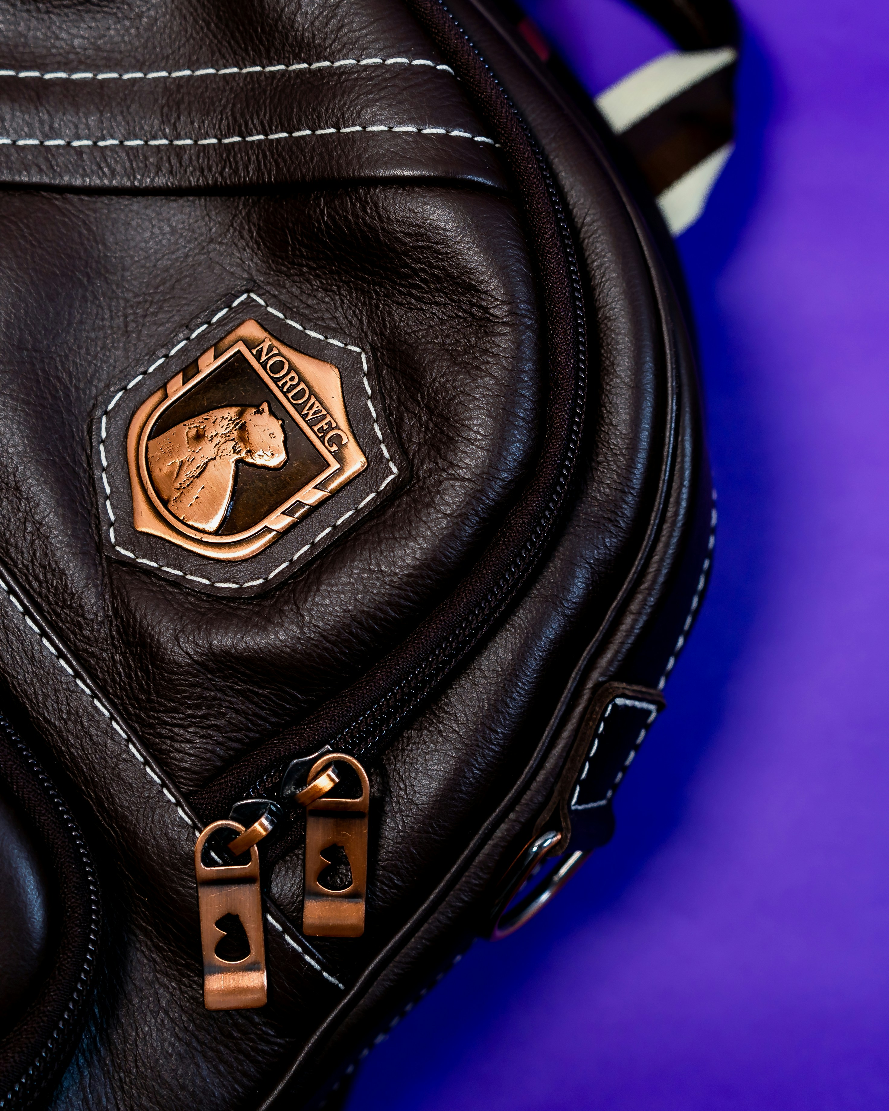 black leather handbag on pink textile