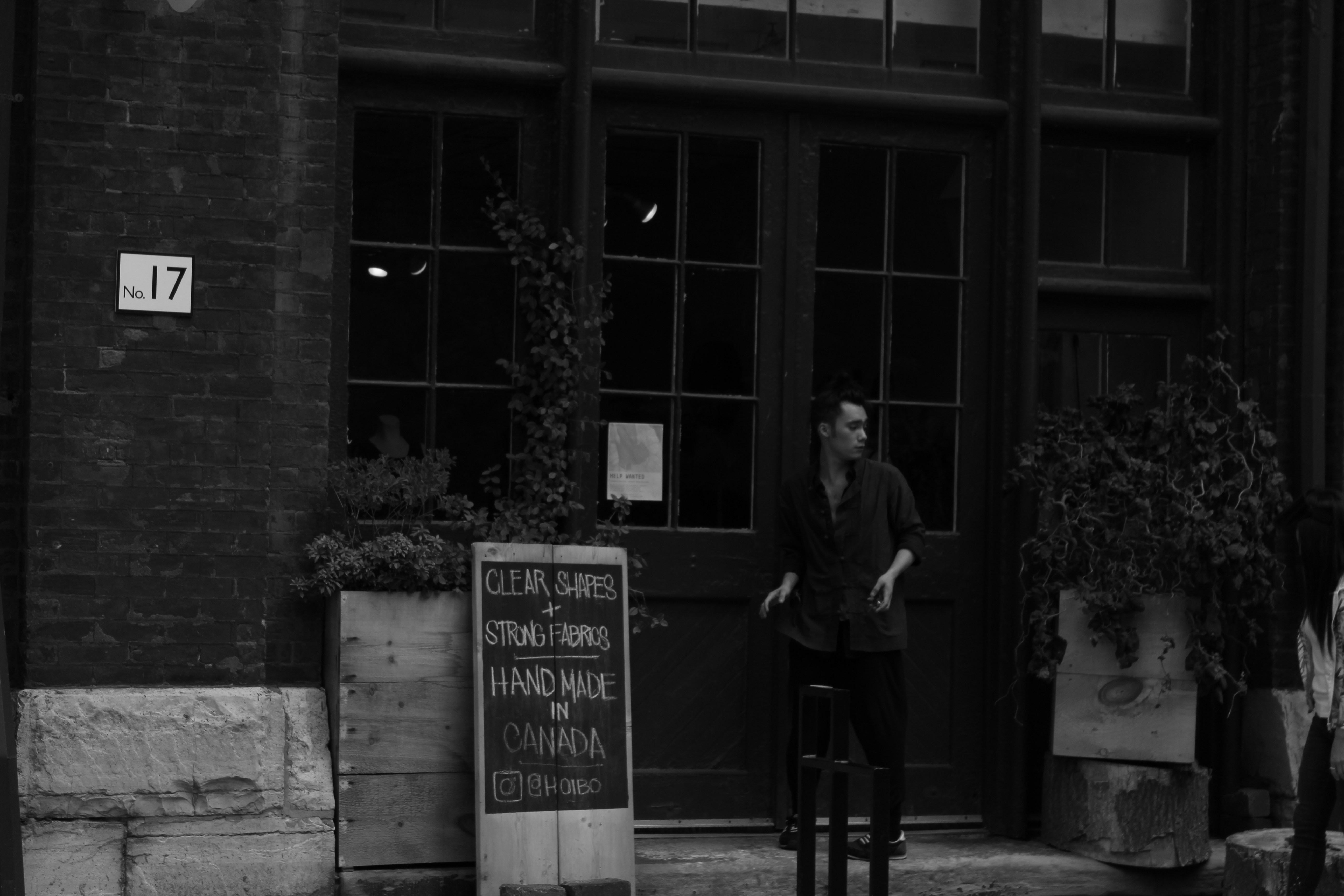 grayscale photo of man and woman standing in front of building