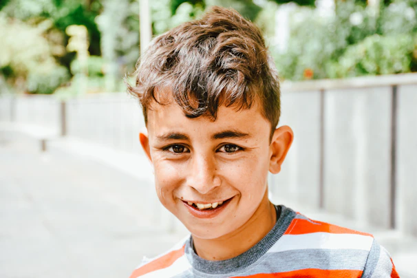 Young boy smiling after a fresh haircut with vibrant afro urban style accents