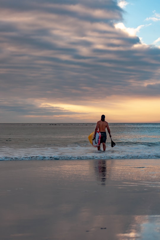 man in black shorts walking on beach during sunset in Melkbosstrand South Africa