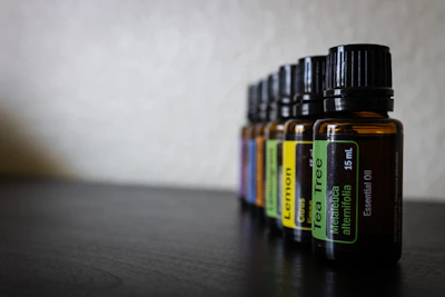 Close-up of amber glass bottles filled with golden essential oils surrounded by fresh wild herbs.