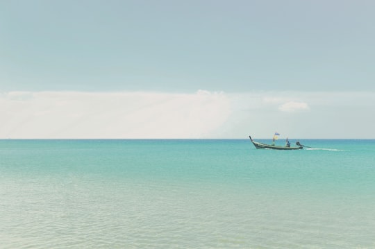 man in blue boat on sea during daytime in Karon Beach Thailand