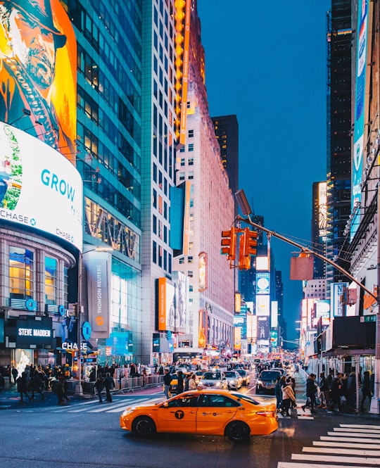 cars on road between high rise buildings during daytime in Times Square United States