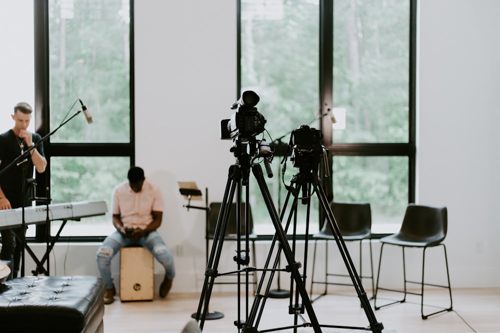 2 men sitting on chair in front of camera