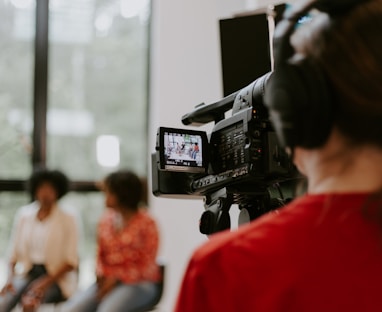 man in red shirt holding black video camera