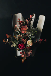 Close-up of hands flipping through a vibrant wellness book with fresh flowers nearby