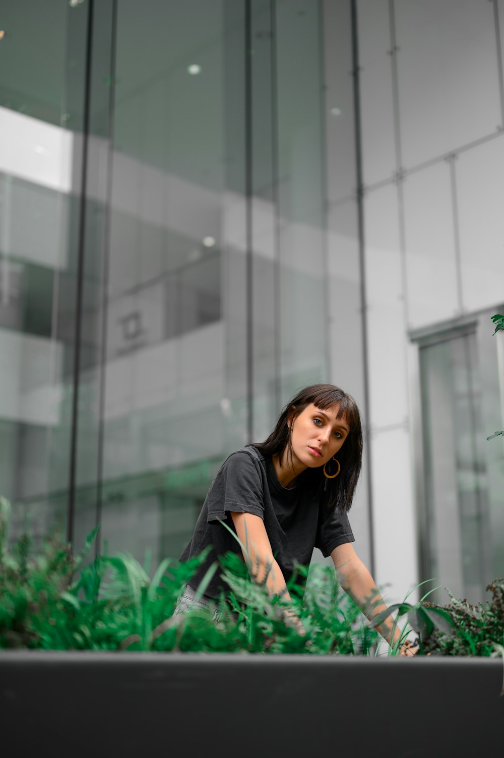 woman in black crew neck t-shirt standing beside green plants during daytime