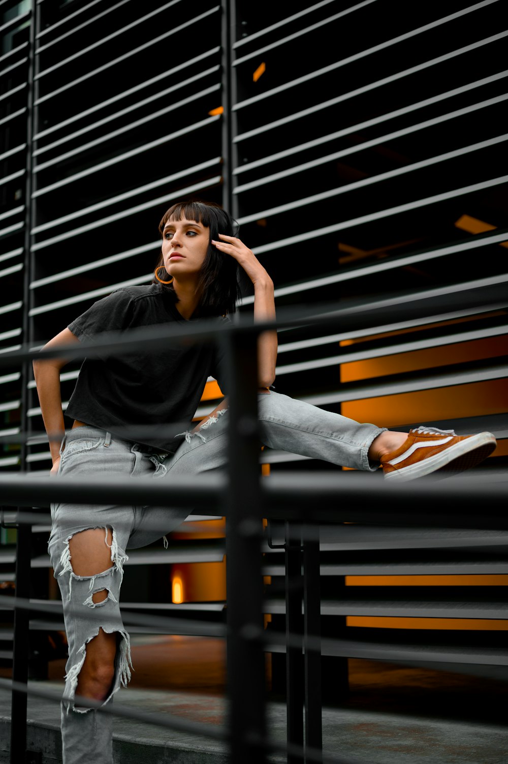 woman in black t-shirt and blue denim jeans sitting on stairs