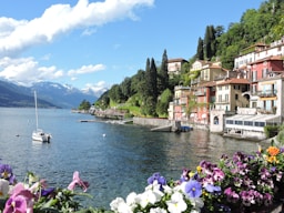 white and brown concrete houses near body of water during daytime