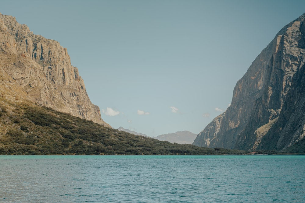 brown rocky mountain beside blue sea during daytime