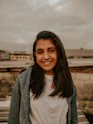 woman in white shirt and blue denim jacket smiling