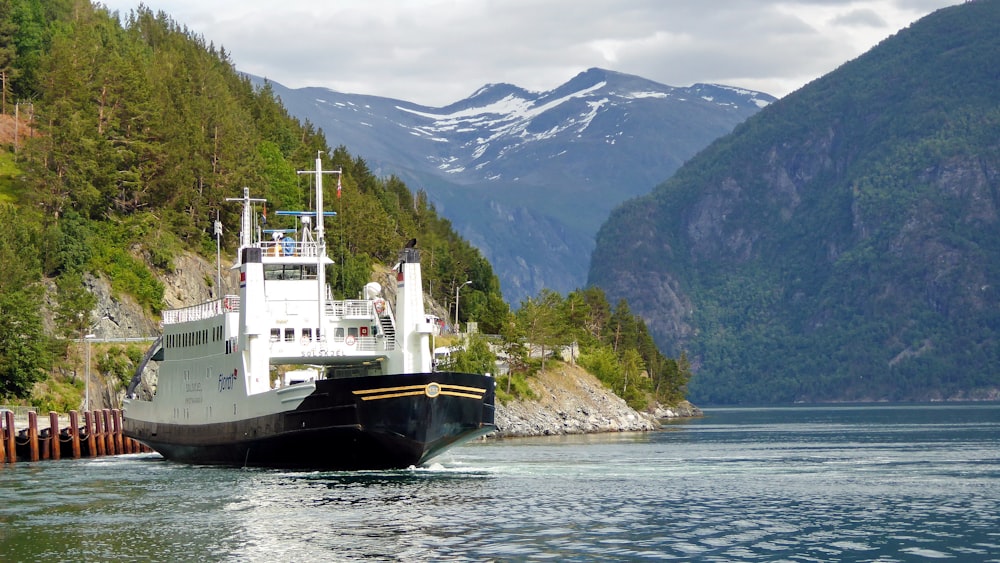 black and white ship on sea near mountain during daytime