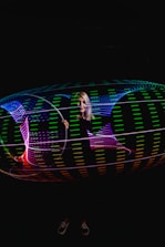 Character editing a vibrant glowing video hologram with neon accents.