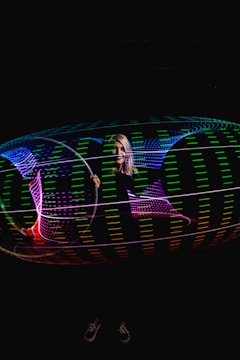 Close-up of a glowing LED dance hoop spinning in the dark.