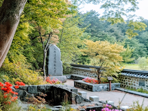 A serene garden setting with gentle sunlight filtering through trees, symbolizing peace and respectful remembrance.