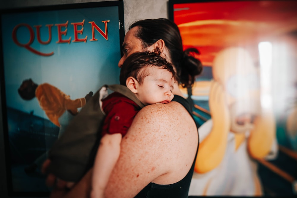 woman in black tank top carrying baby