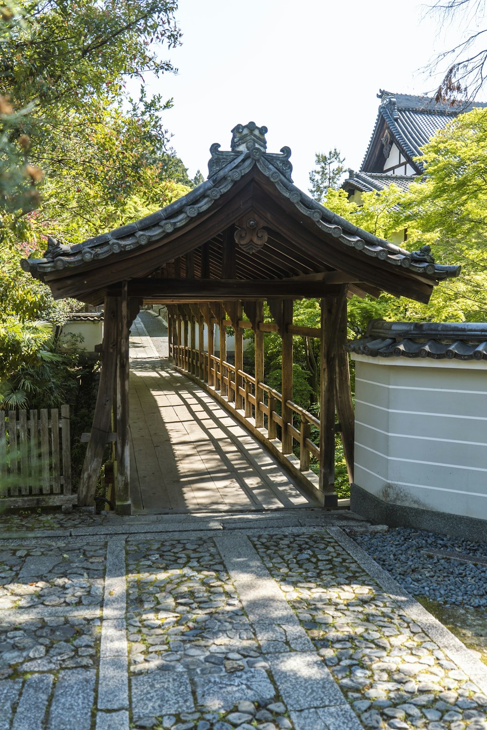 a wooden gazebo sitting next to a white fence