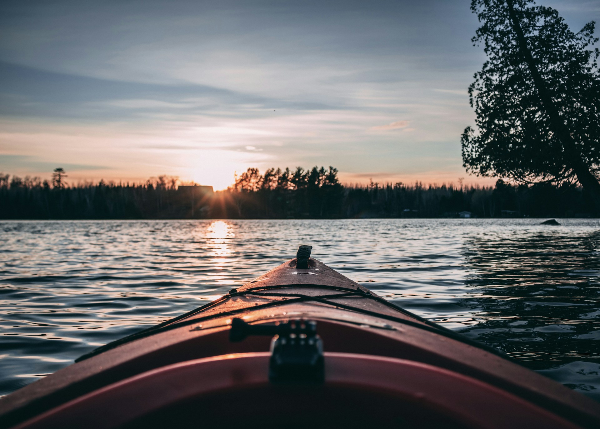 person riding on boat on lake during sunset