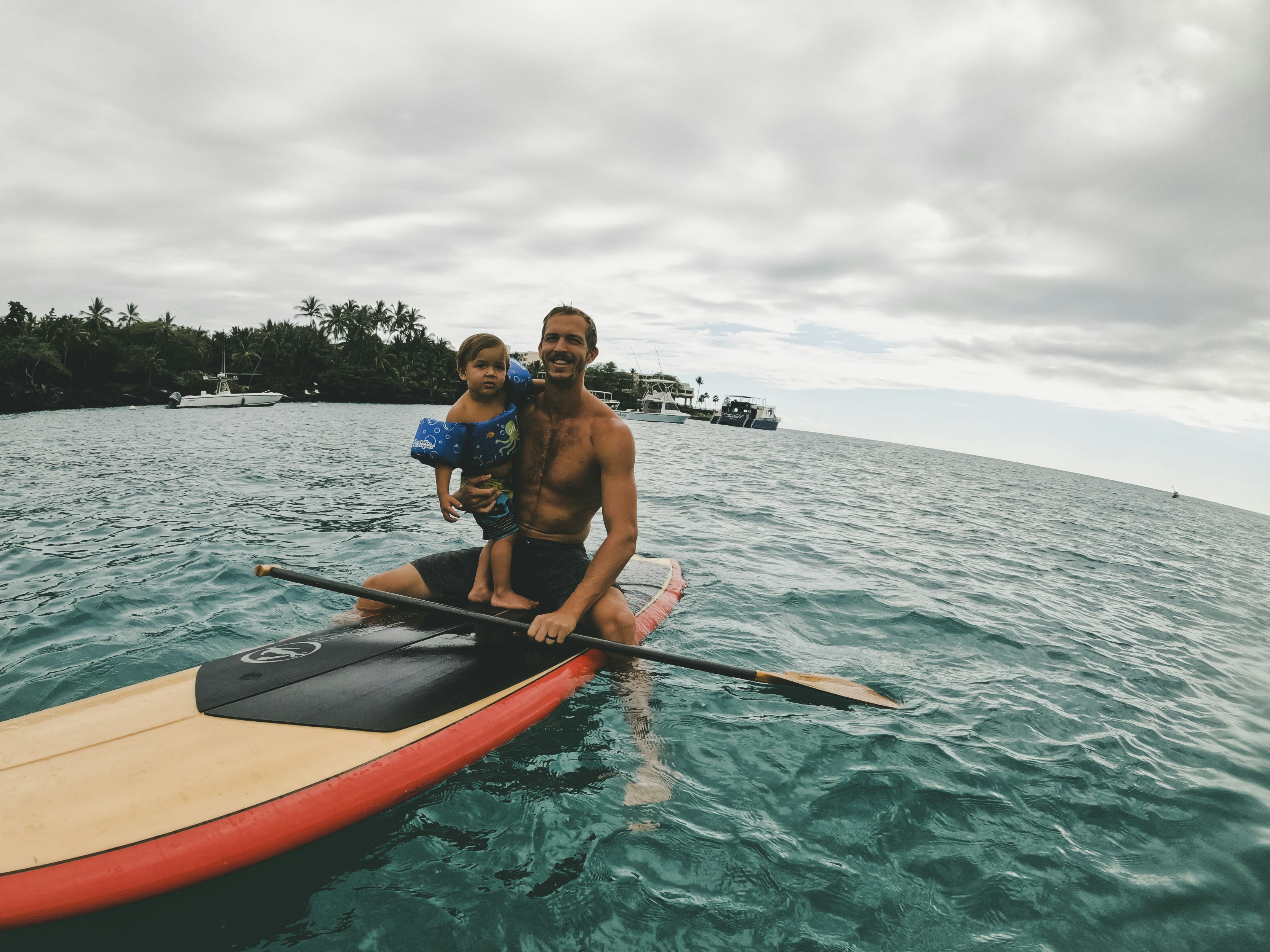 2 men riding on orange kayak on sea during daytime, Paddle Boarding with my son