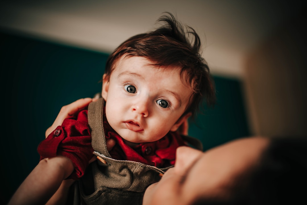 boy in red hoodie lying on black textile