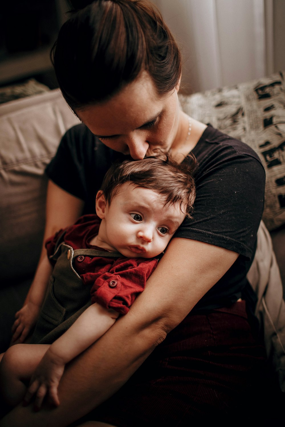 man in black crew neck t-shirt carrying baby in red dress