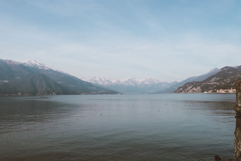 body of water near mountain under blue sky during daytime