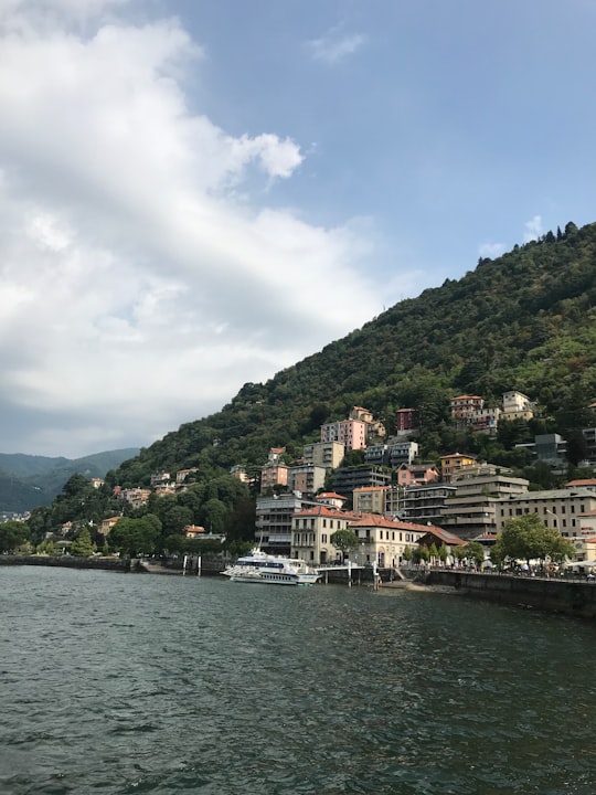 white and brown concrete building near body of water during daytime in Lake Como Italy