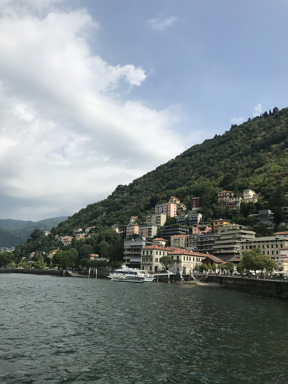 Bâtiment en béton blanc et brun près d’un plan d’eau pendant la journée