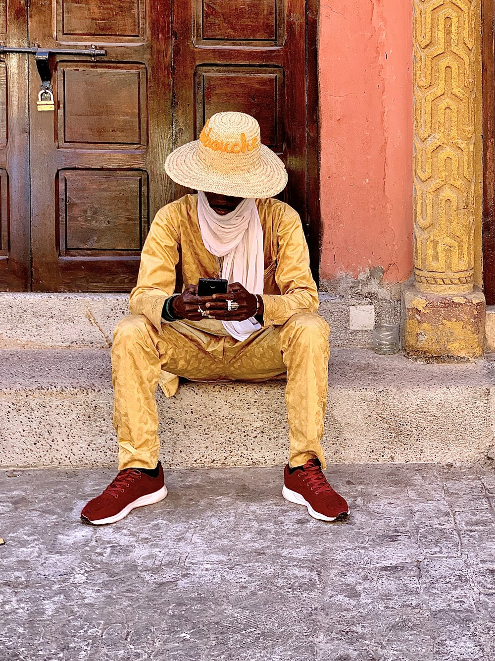 man in yellow thobe sitting on floor