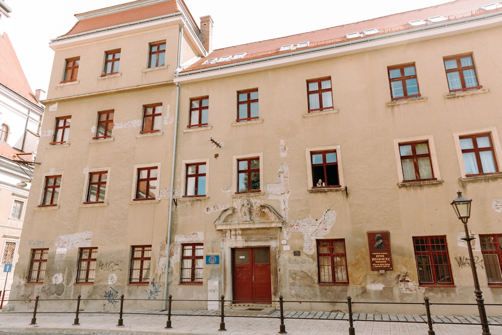 brown concrete building with red wooden door