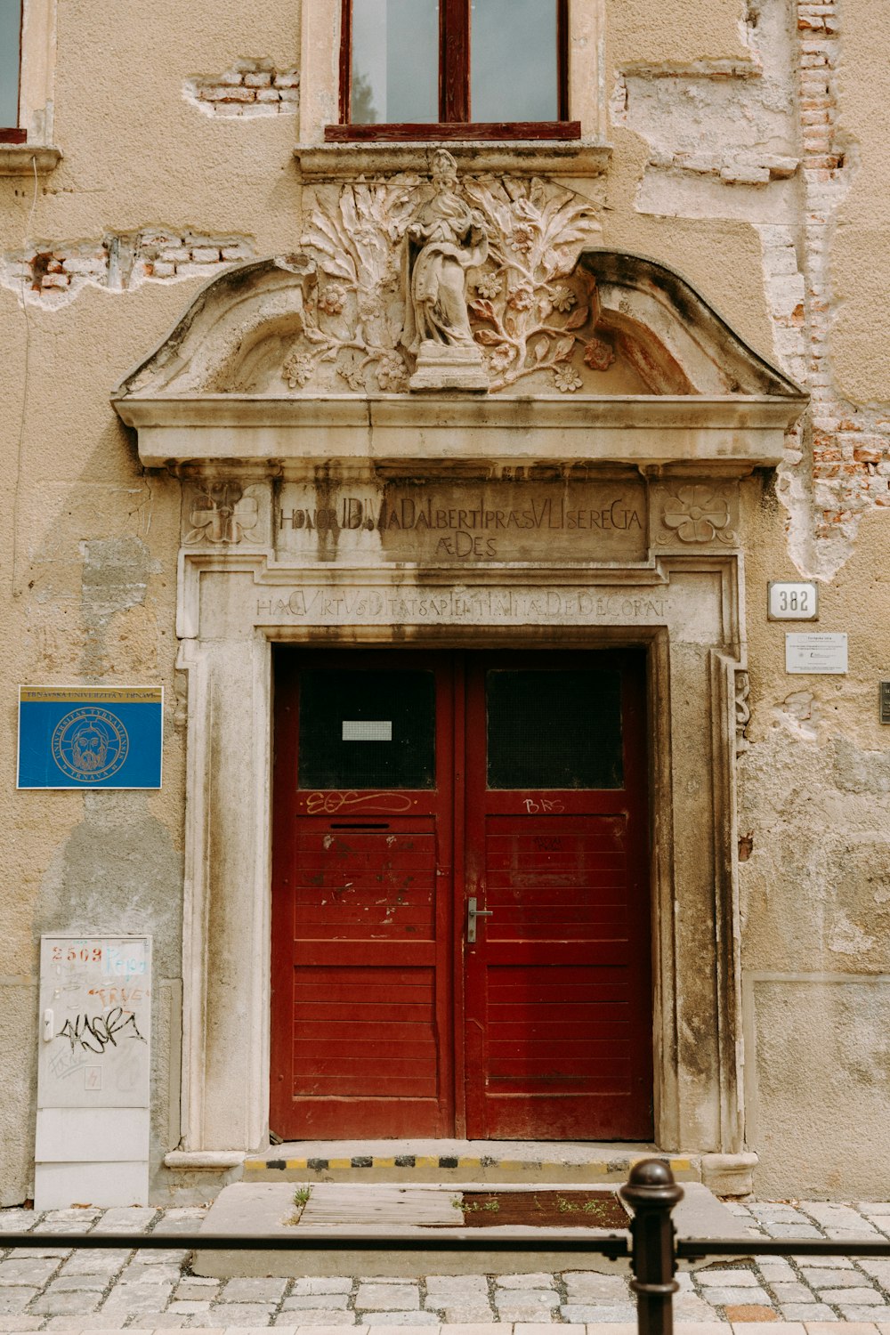 red wooden door with gold statue