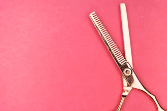 silver scissors on red textile