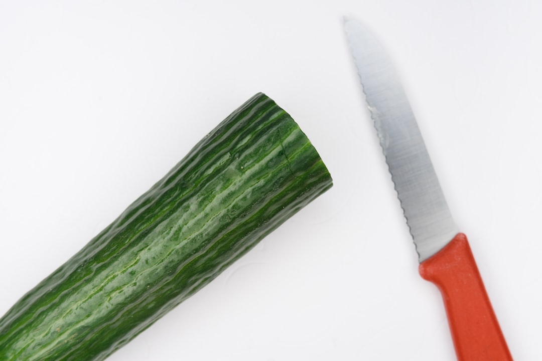 red handled knife beside green vegetable