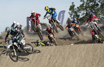 man in blue and yellow jacket riding motocross dirt bike