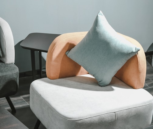 white and brown throw pillow on white sofa chair