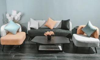 Living room with minimalistic black furniture and subtle pink details.