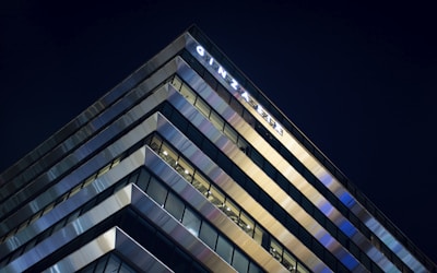 Exterior view of a sleek Tokyo high-rise apartment building at dusk with city lights glowing.