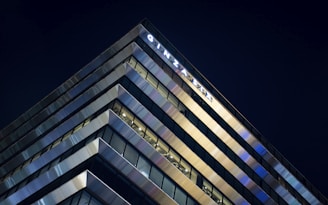 Exterior view of a sleek Tokyo high-rise apartment building at dusk with city lights glowing.