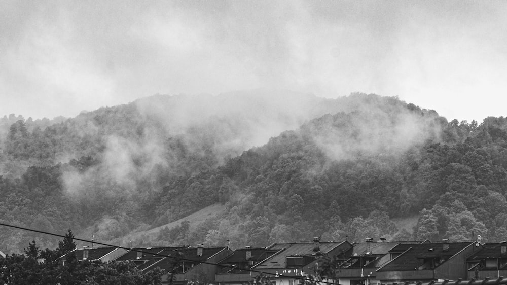 grayscale photo of houses near mountain