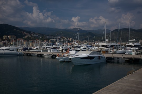 white and blue boats on sea dock under blue and white cloudy sky during daytime in Varazze Italy