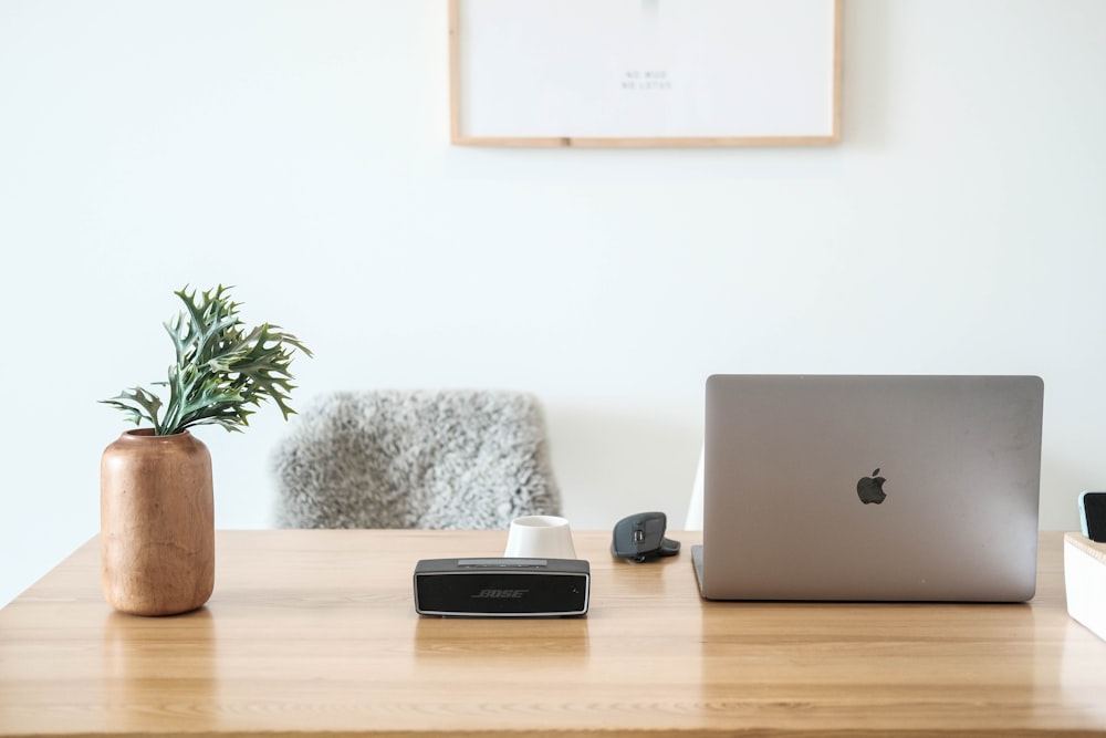 macbook pro na mesa de madeira marrom