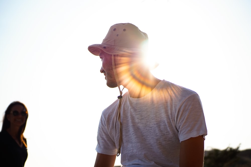 man in white crew neck t-shirt wearing white cap